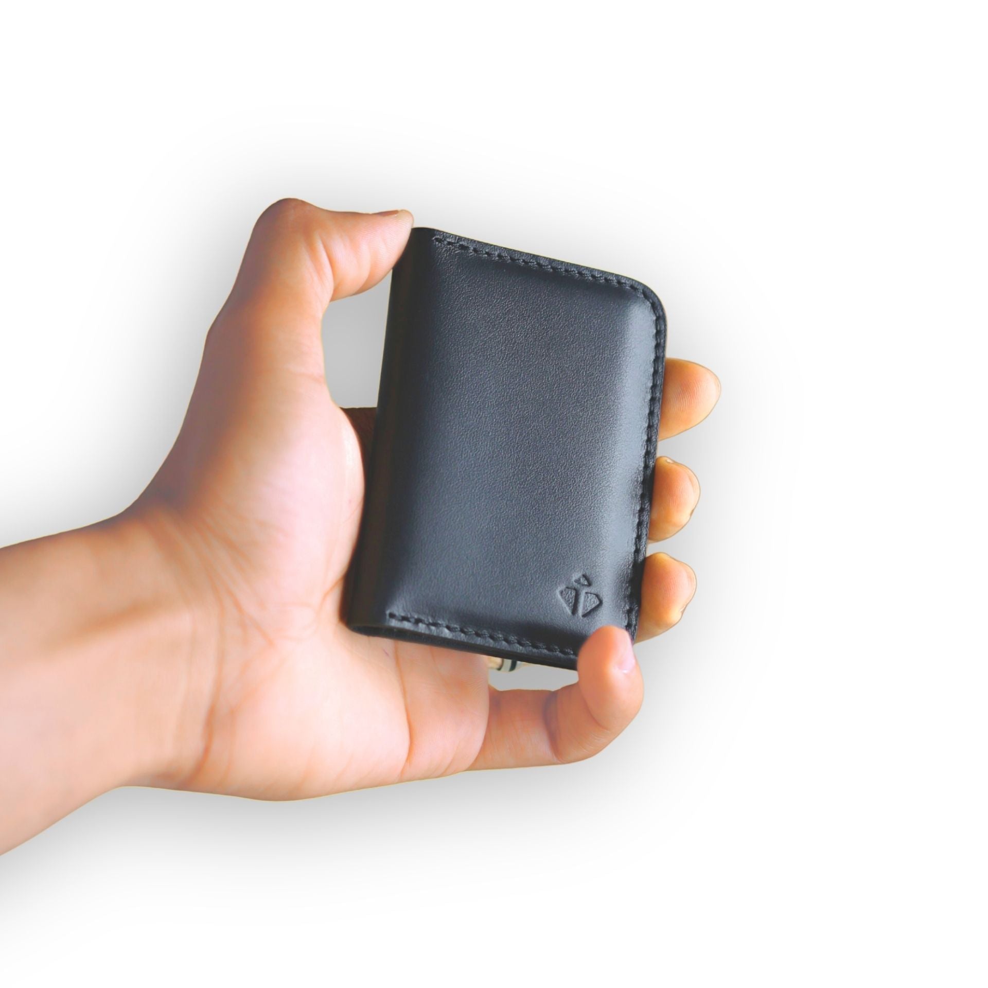 Hand holding a black leather wallet against a white background